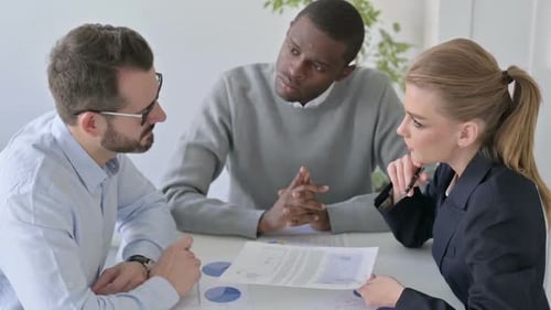 Serious Business People Discussing Documents in Office