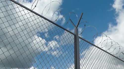 Barbed Wire Chain Link Fence Against Skyline Timelapse at the Restricted Area