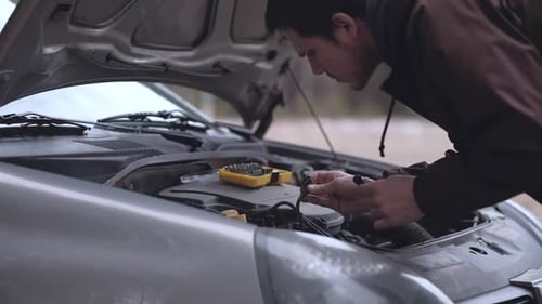 Close-up - Man repairing broken car.