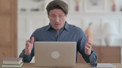 Man Reacts with Surprise While Using Laptop