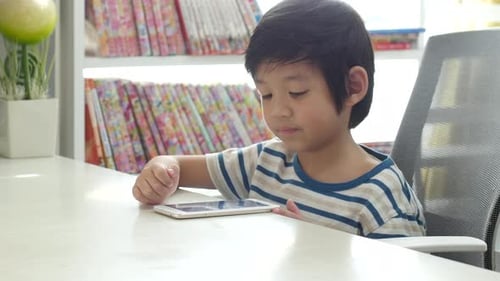Happy Asian Child Using Mobile Phone On White Table