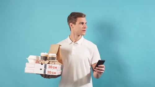 Lächelnder positiver Liefermann mit Smartphone