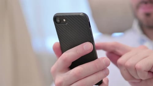 Close Up of Casual Young Man Using Smartphone