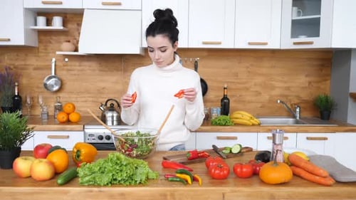 Woman Prepares Healthy Salad in Bright Kitchen