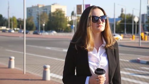 Woman Walking Confidently with Coffee in City