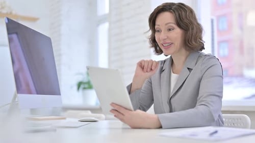 Woman Video Chatting on Tablet in Office