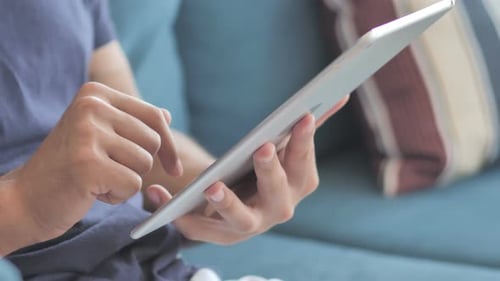 Hands Using Tablet While Sitting on Couch