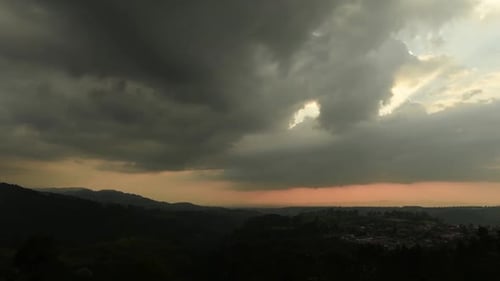 Zeitrafferaufnahme von Wolken, die sich bei Sonnenuntergang über der Landschaft zusammenziehen