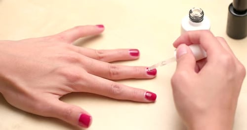 Apply red nail polish on finger nail at home
