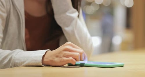 Woman working on smart phone in cafe