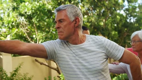 Adults Stretching Arms Outdoors in a Sunny Group