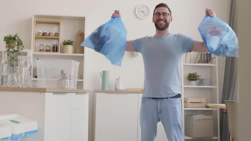 Hombre feliz con bolsas de basura