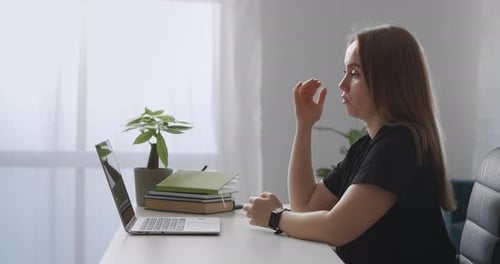 Une coach féminine consulte en ligne en parlant à la webcam d'un ordinateur portable expliquant et gesticulant Webinaire