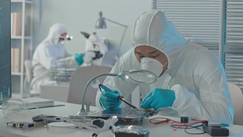 Scientist Soldering Circuit Board in Lab Setting