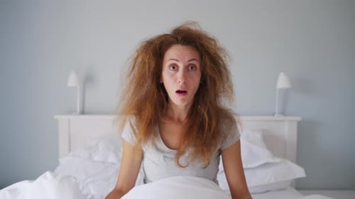 Shocked Woman Waking up in Bed