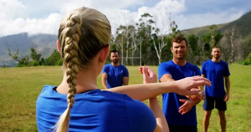 Female trainer training people in boot camp 4k