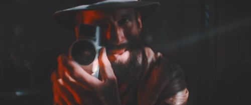 Mysterious Man Filming with Vintage Camera in Red Light