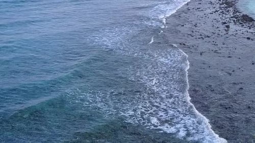 Leere Natur des Uferstrandes vor blauem Meer und Sandhintergrund nach Sonnenaufgang