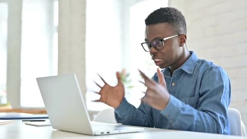 Young Man Expressing Frustration With Laptop