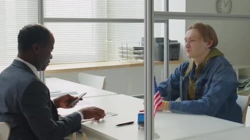 Young Man Having Visa Interview with Consulate Officer