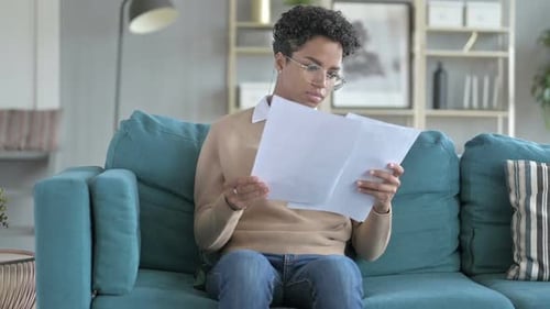 Woman Celebrates Positive News While Reading Documents