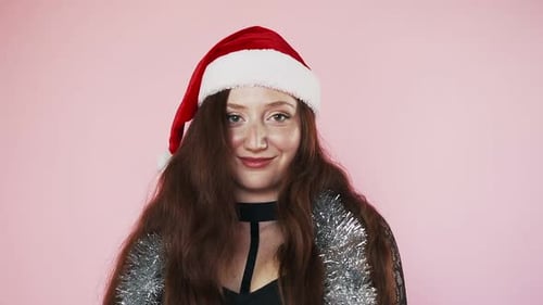 Smiling Woman Wearing a Santa Hat and Tinsel