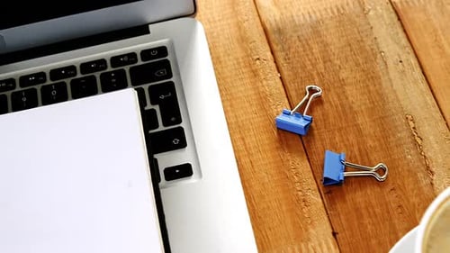 Laptop, Coffee, and Clips on Wooden Desk