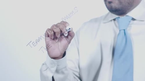 Asian Businessman Writes Teamwork Makes The Dream Work