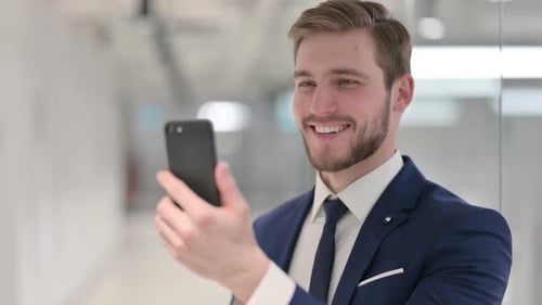 Man in Suit Video Calling on Smartphone