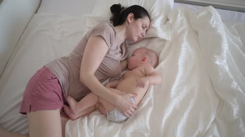 Mother and Baby Sleeping Peacefully in White Bed