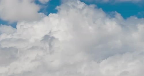 Fluffy White Clouds Moving Across Blue Sky
