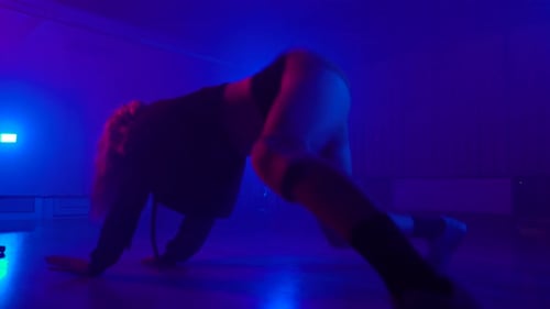 Woman performing twerk in dark dance studio