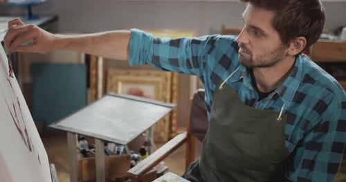 Man Painting a Portrait in Art Studio