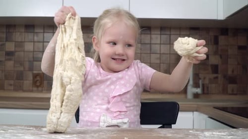 Happy Child Playing with Dough in Kitchen