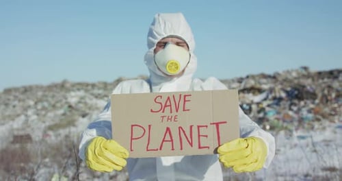 Person in Hazmat Suit Holds Save the Planet Sign