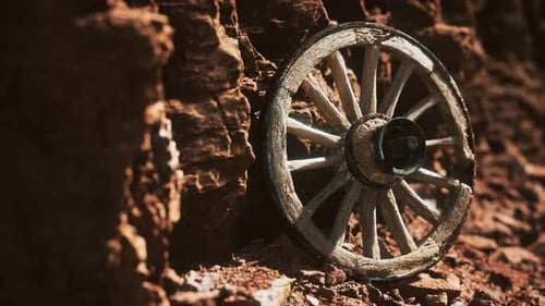 Old Wooden Wagon Wheel on Rocky Desert Ground