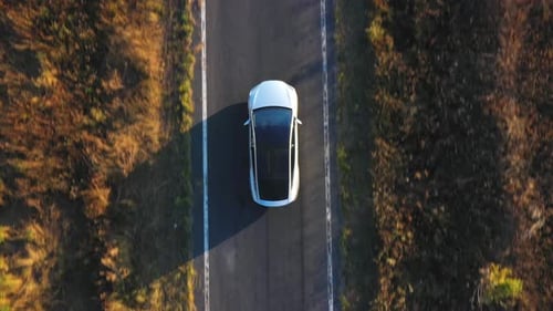Aerial Shot of Electrical Car Driving on Country Road at Summer Evening