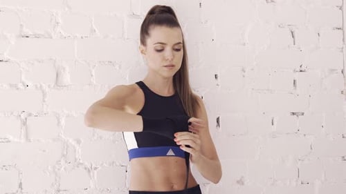 Young Woman Wrapping Hands For Boxing Training