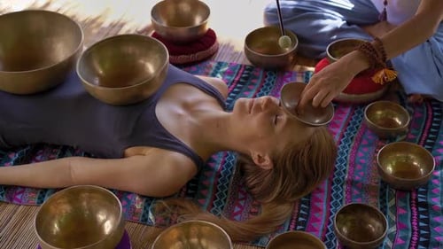 Woman Receives Sound Healing Therapy with Singing Bowls