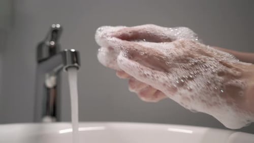 Hand Washing in Bathroom Sink with Soap