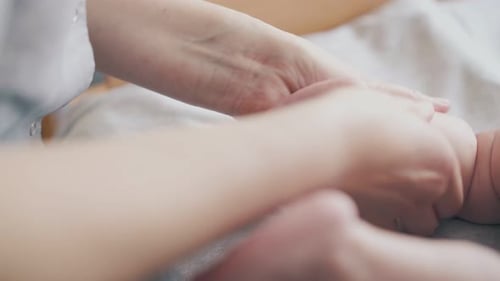 Parent Massaging Arm of Sweet Infant