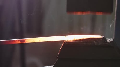 Blacksmith Using Hammer Machine for Shaping Hot Metal Blank in Forge Workshop