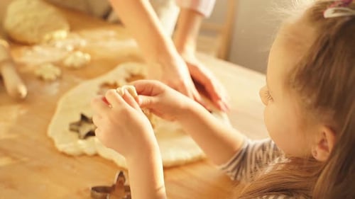 La niña y su madre preparan galletas para las vacaciones