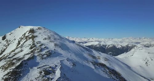 Aerial drone view of snow covered mountains in the winter.
