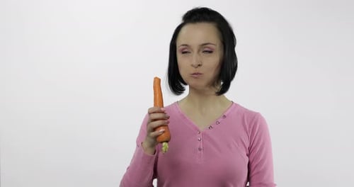 Woman Eats Fresh Carrot with Pleasure