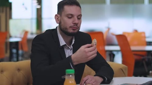 Man in Suit Eating Sandwich at Workplace