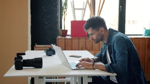 Photographer Editing Photos After Photoshoot Using Laptop in Studio Typing