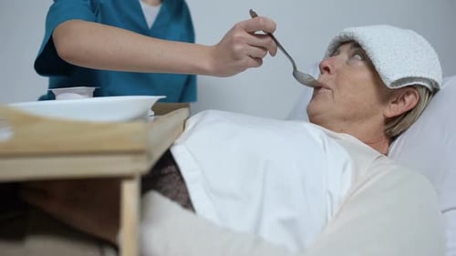 Medical Worker Helping Weak Woman to Eat, Properly Care for Patient in Hospital