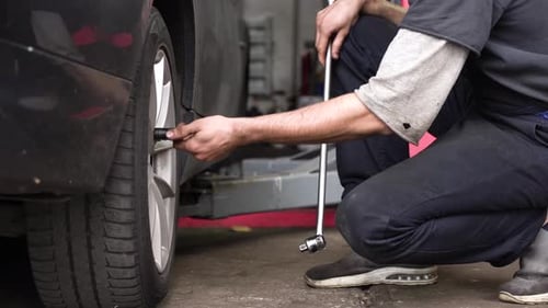 auto mechanic spins the wheel of the car. car workshop.