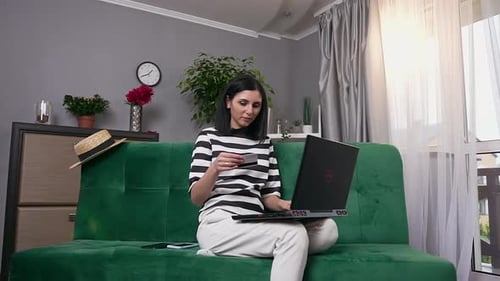 Woman Using Laptop and Credit Card at Home